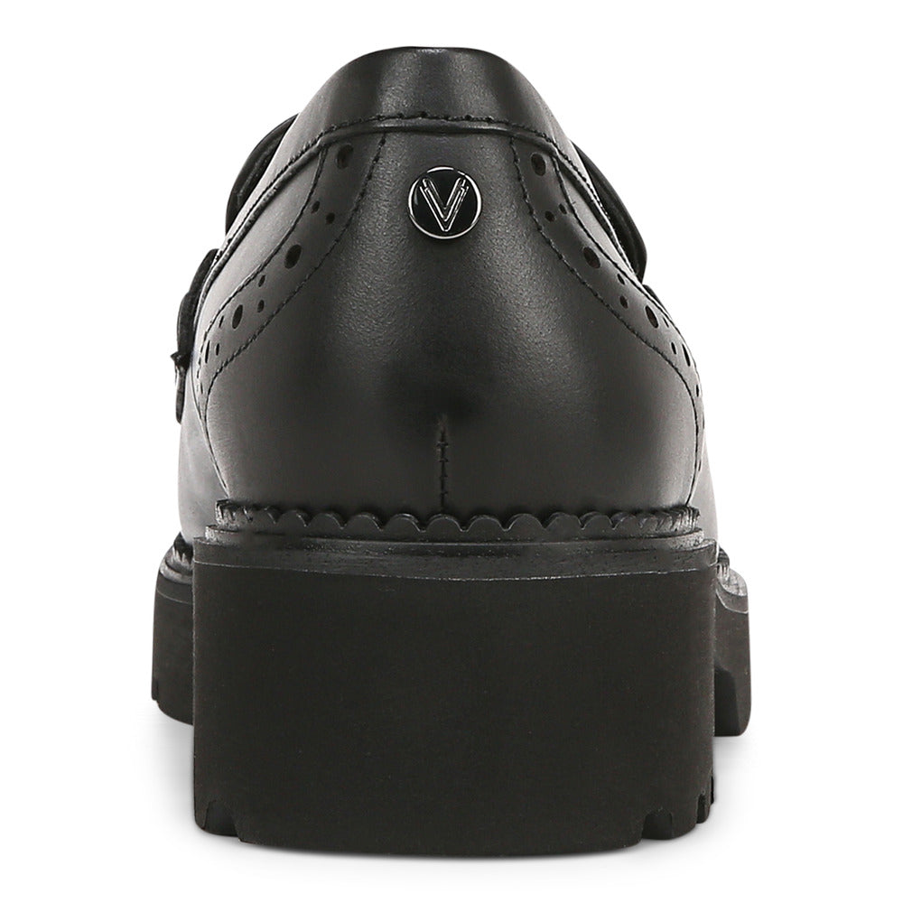 Back view of a black leather platform Mary Jane with a buckle strap and decorative perforations.