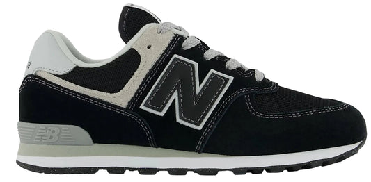 A New Balance 574 sneaker in black, white, and gray with a black 'N' logo.