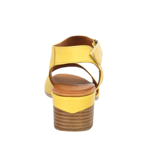 Back view of a yellow leather sandal with a block heel and a Velcro strap.