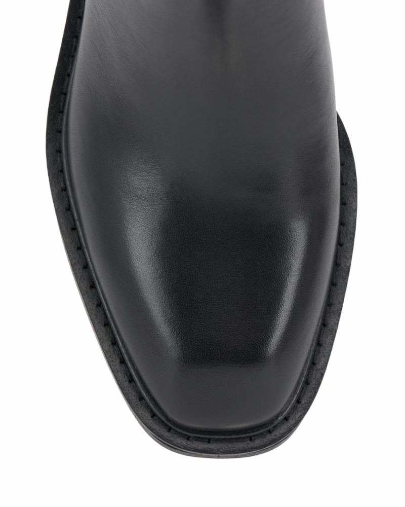 Close-up of a black, smooth leather square-toe dress boot.