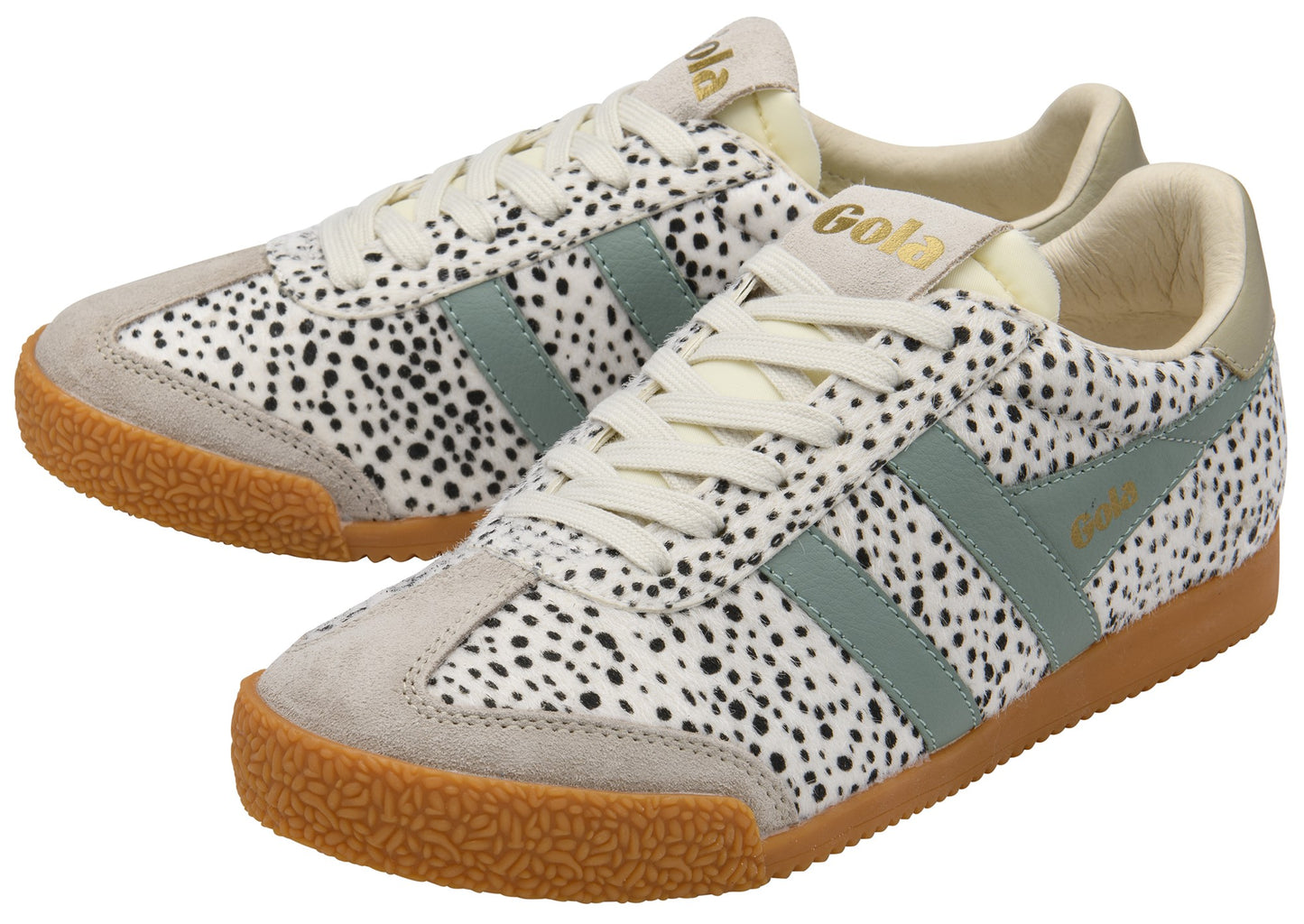 A pair of off-white sneakers with black spots, green stripes and gold accents.