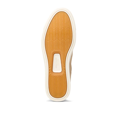 A tan shoe sole with wave-like treads.