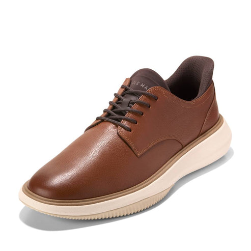 A brown leather oxford dress shoe with a thick, off-white sole.