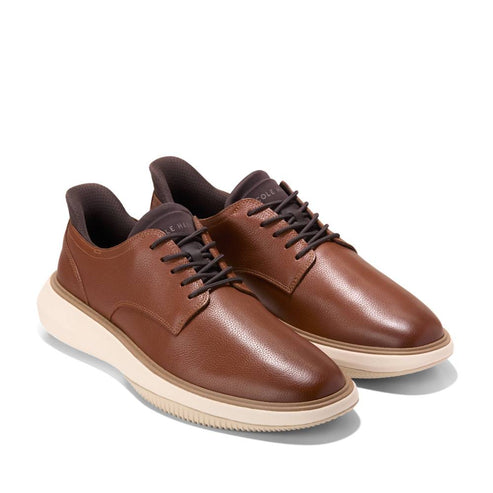 Pair of brown leather shoes with dark laces and thick white soles.