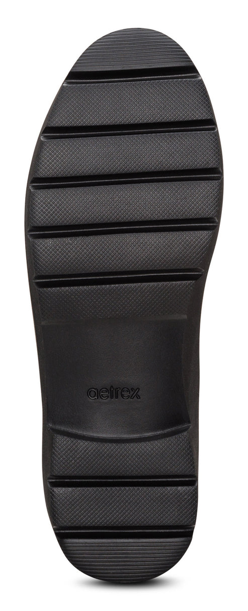 The black shoe sole has horizontal tread grooves and a flat surface.