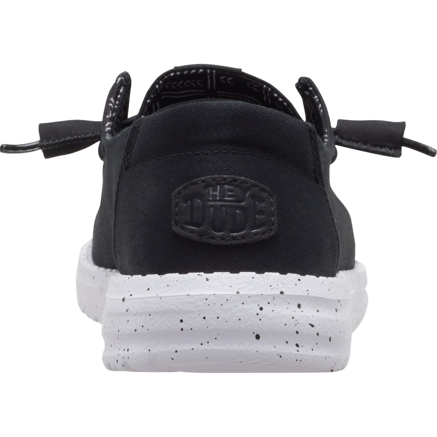 Black casual slip-on shoe with white speckled sole, displaying the text "HE DUDE".