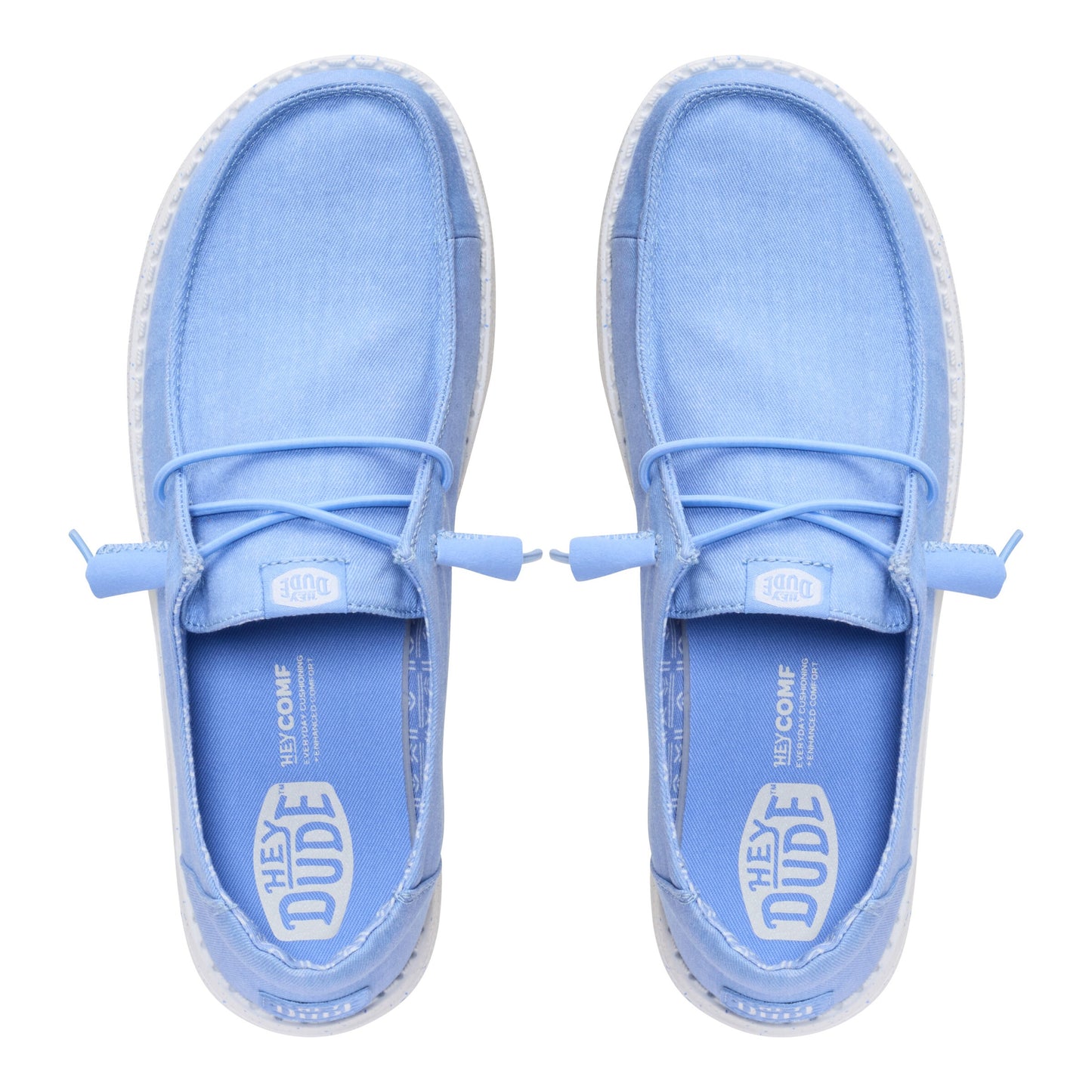 Top-down view of two light blue casual shoes with laces, interior tag that reads HEY DUDE HYCOMF