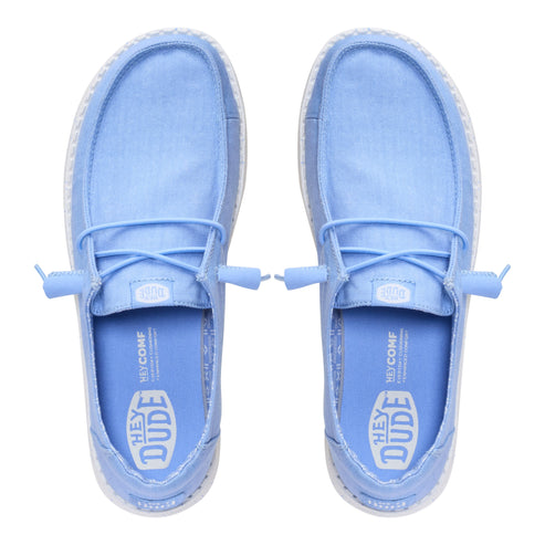 Top-down view of two light blue casual shoes with laces, interior tag that reads HEY DUDE HYCOMF