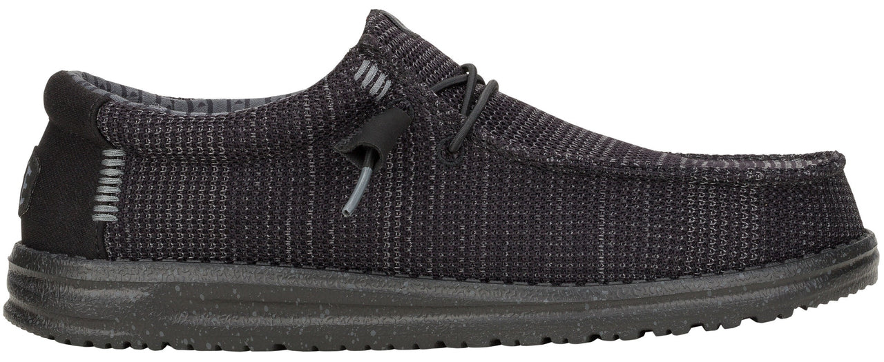 A low-profile, dark gray shoe with a textured upper, laces, and a thick sole.