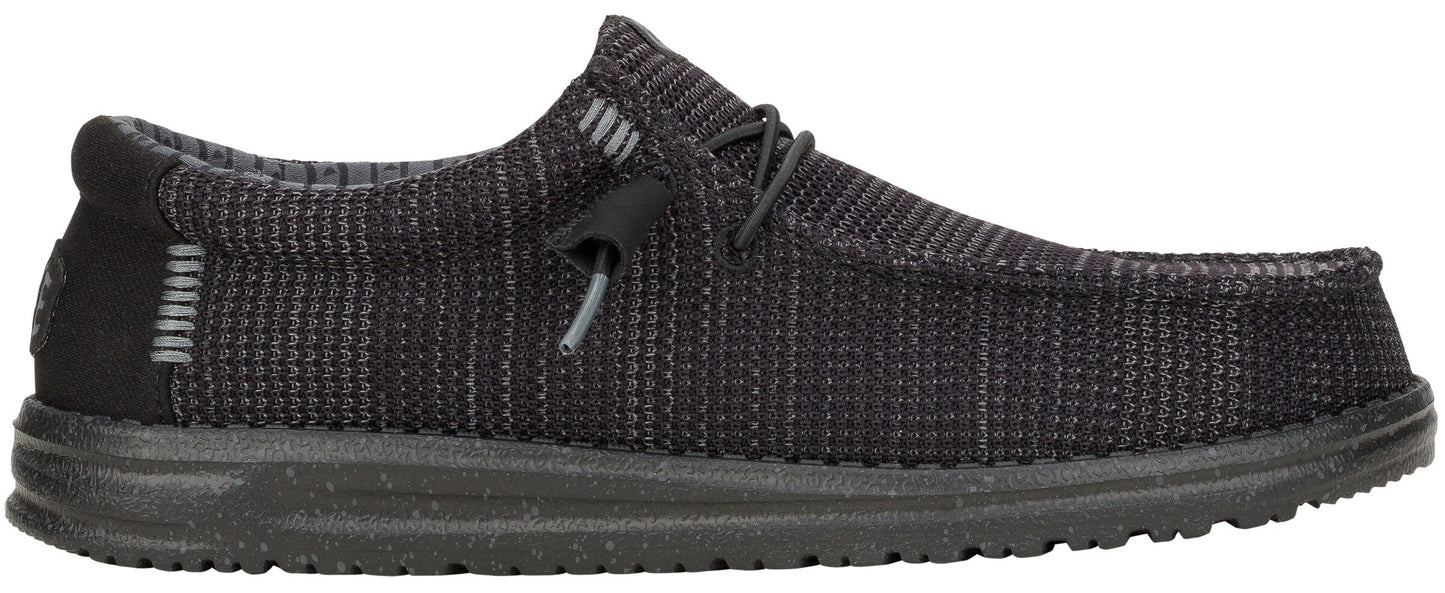 A low-profile, dark gray shoe with a textured upper, laces, and a thick sole.