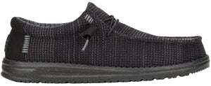 A low-profile, dark gray shoe with a textured upper, laces, and a thick sole.