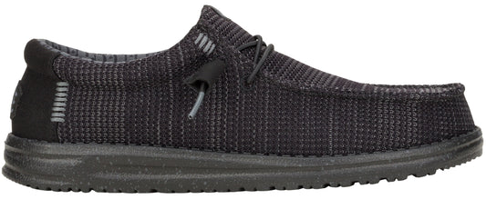 A low-profile, dark gray shoe with a textured upper, laces, and a thick sole.