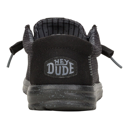 Back view of a black slip-on shoe with visible "HEY DUDE" logo on the heel.