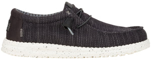 A charcoal-grey slip-on shoe with a white speckled sole.