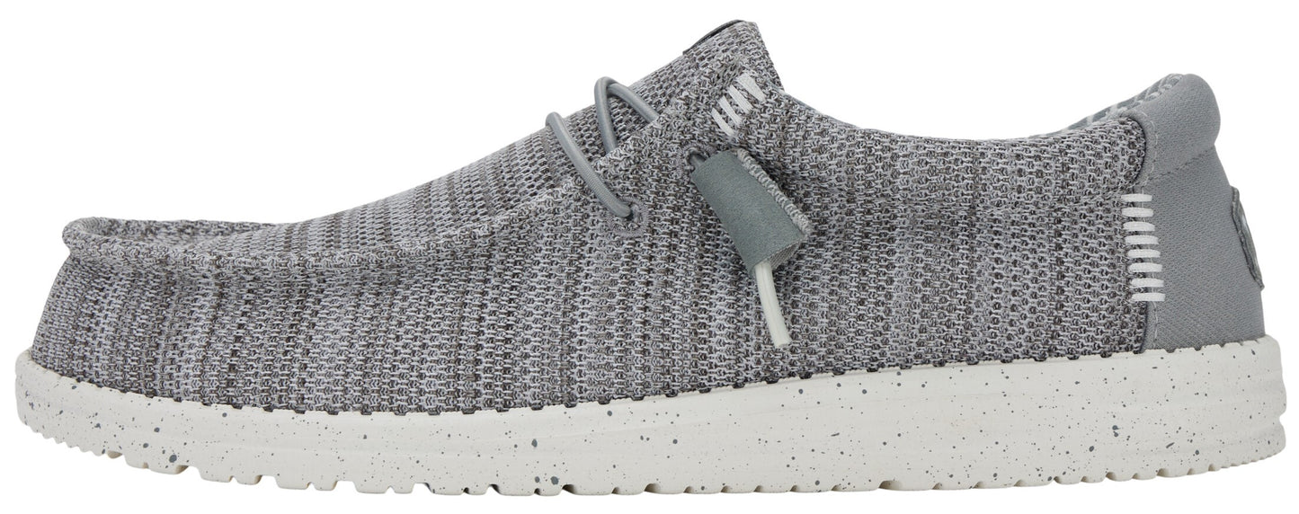 A slip-on shoe in a gray knit fabric, featuring a speckled white sole and gray elastic laces.