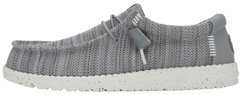 A slip-on shoe in a gray knit fabric, featuring a speckled white sole and gray elastic laces.