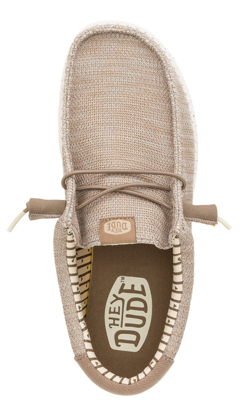 A top-down view of a light brown, woven-texture slip-on shoe with a rounded toe and laces, featuring a dark brown insole with a white brand logo and a striped interior lining.