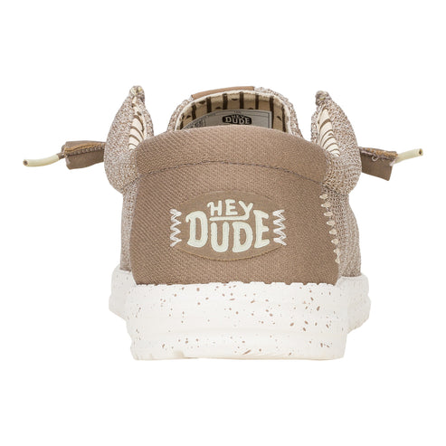 Taupe colored slip-on shoe with white speckled sole and “HEY DUDE” logo on the heel.