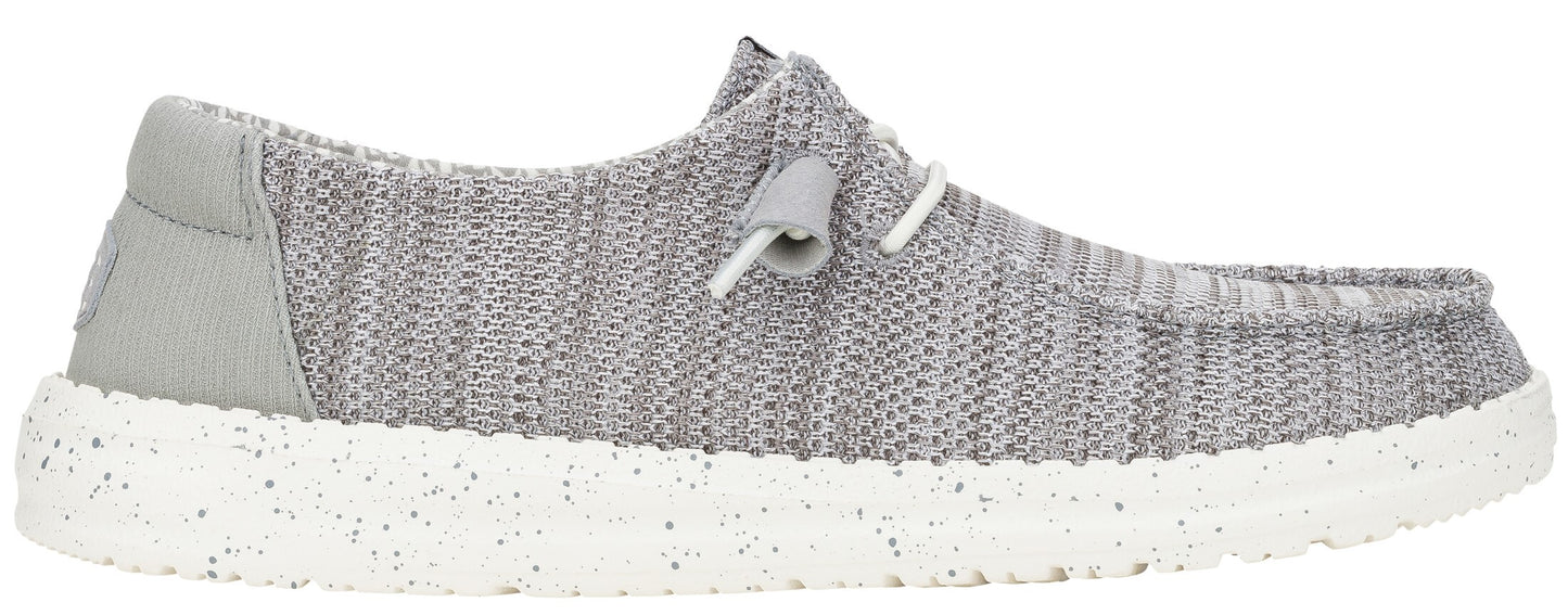 A grey shoe with white laces and a speckled white sole.