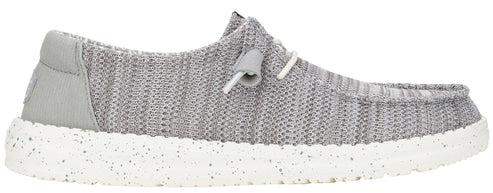 A grey shoe with white laces and a speckled white sole.