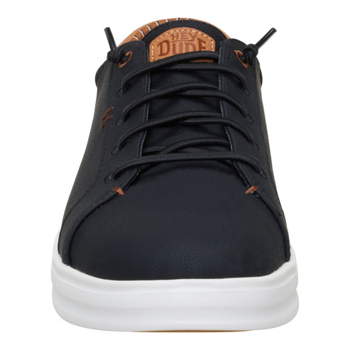 Black casual shoe with white sole, black laces, and a visible tag saying HEY DUDE.