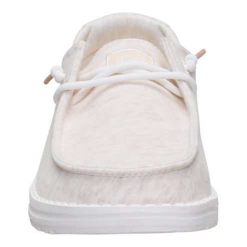 Front view of a slip-on shoe with white laces and a textured white upper, contrasted by a white sole.