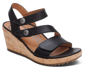 Black wedge sandal with two adjustable straps, silver buttons, and a cork wedge.