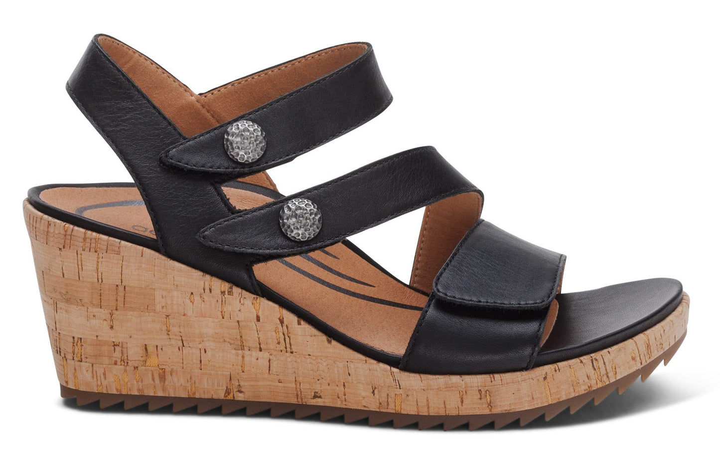 Black wedge sandal with cork heel and dual straps, secured with decorative buttons.