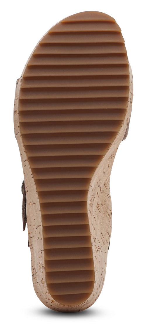 The sole of a platform sandal with ridged brown rubber.