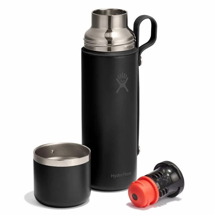 Black metal insulated bottle with silver top, black handle, detached black metal cup, and detached stopper with red detail.