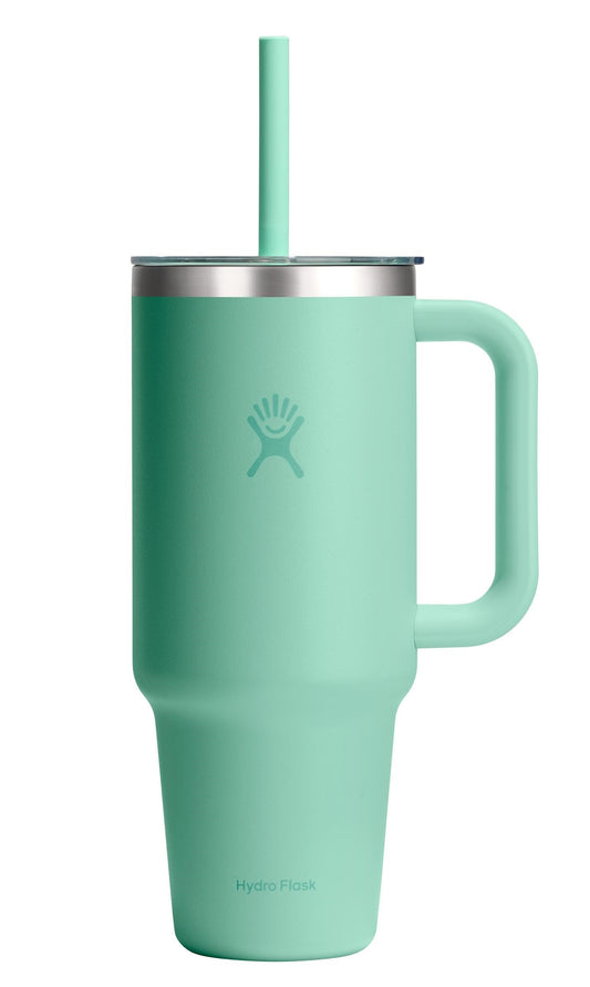 A tall, light green tumbler with handle, lid, and a straw.