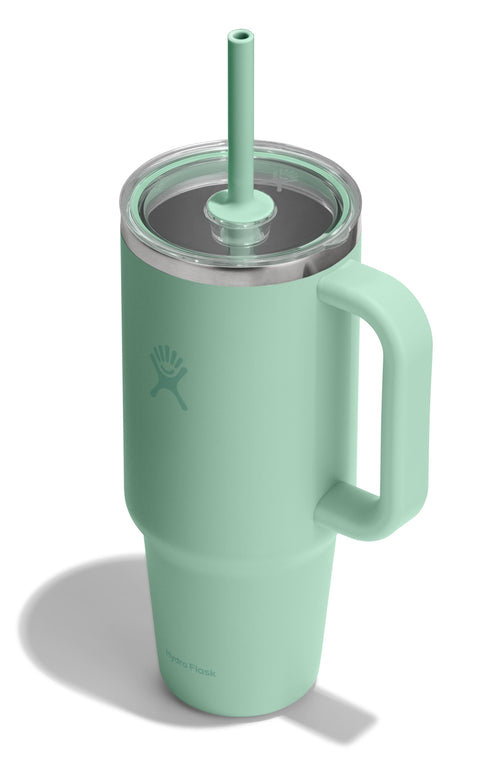 A light green insulated mug with a clear lid, a straw, and a handle.