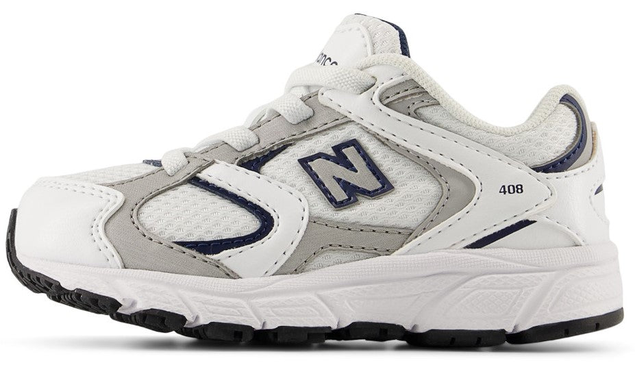 Low-top athletic shoe with white and gray upper, navy accents, white sole, and black bottom.