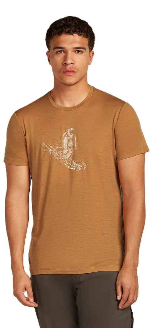 A man wearing a brown t-shirt with an illustration of a person on skis.