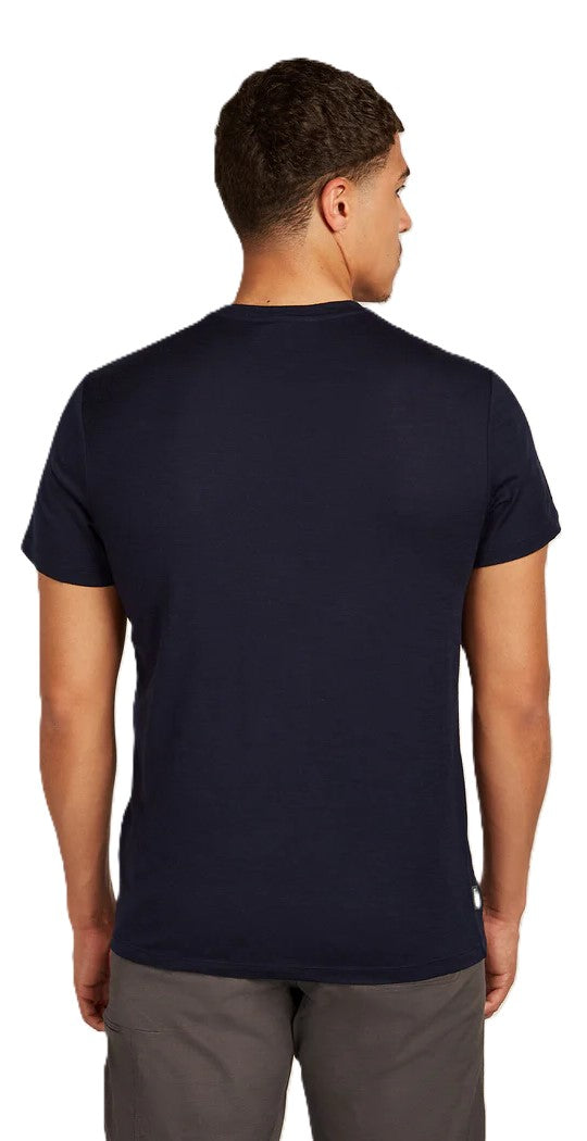 Man wearing a dark blue t-shirt and gray pants, viewed from the back.