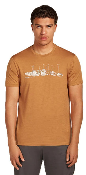 A man wearing a brown t-shirt with a white mountain range illustration.