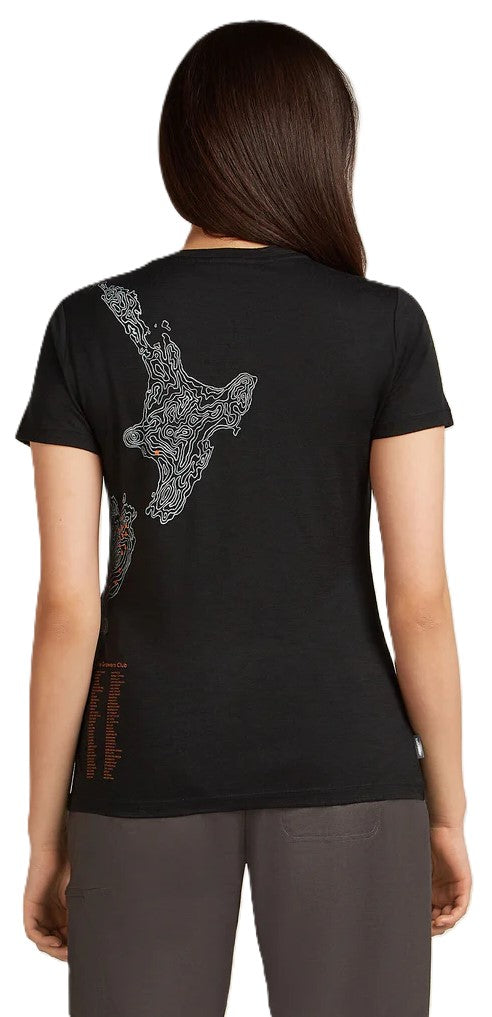 A woman wears a black T-shirt with a decorative map of New Zealand on the back.