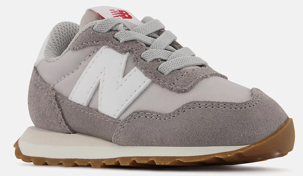Toddler sneaker: grey suede toe, off-white midsole and gum outsole, and an oversized white “N” logo.