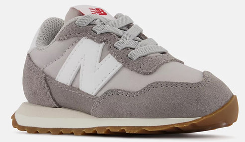 Toddler sneaker: grey suede toe, off-white midsole and gum outsole, and an oversized white “N” logo.