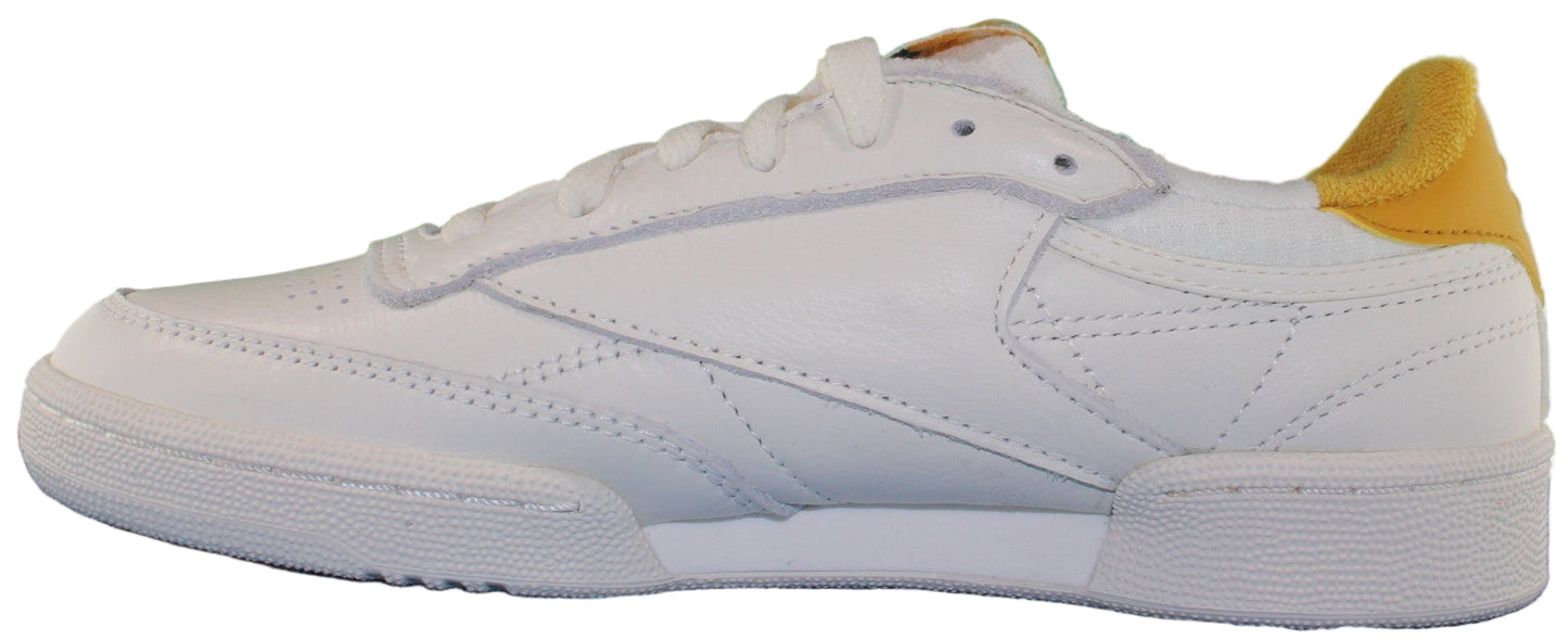 A white sneaker with yellow heel.