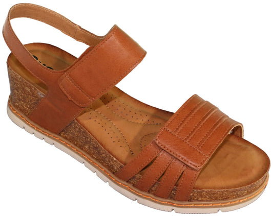 Tan leather sandal with adjustable straps, cork wedge heel and white sole.