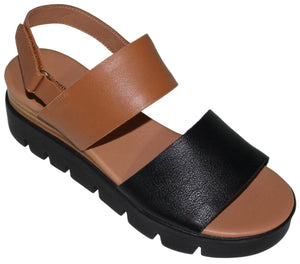 Platform sandal with a black strap over the toes and a brown strap over the instep; black treaded sole and adjustable ankle strap.