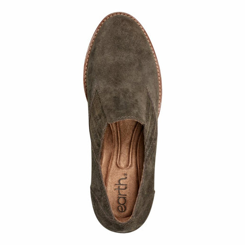 Close-up top view of a green suede slip-on shoe with a round toe and Earth branding on the insole.