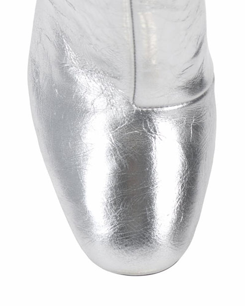 Metallic silver round toe of a shiny boot.