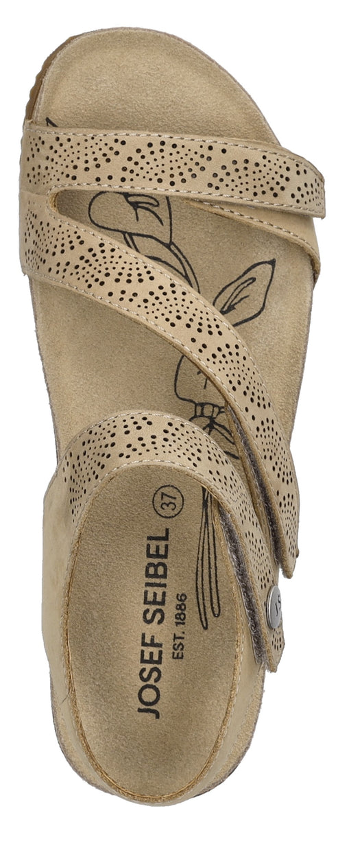 An overhead shot of a beige sandal with decorative perforations and flower imprint.