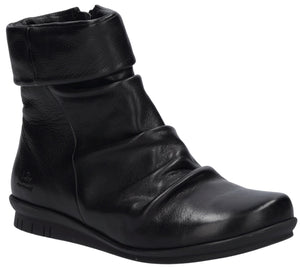 A black leather ankle boot with a folded cuff top and a ruched, gathered upper, set on a flat, textured black rubber sole.