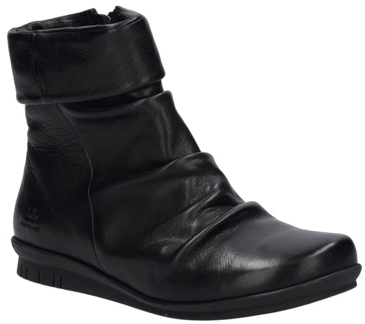 A black leather ankle boot with a folded cuff top and a ruched, gathered upper, set on a flat, textured black rubber sole.