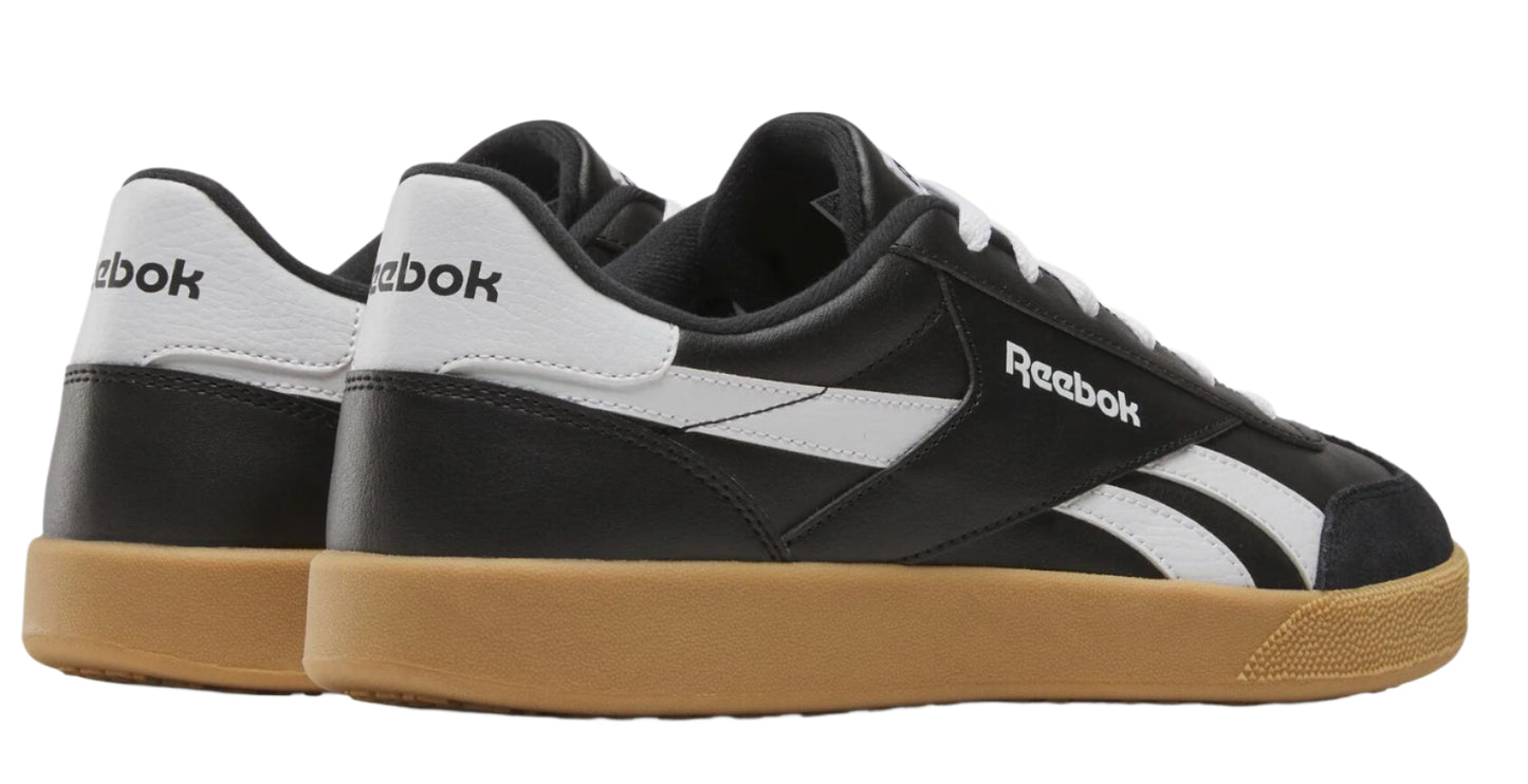 Low profile sneakers in black with white accents and gum soles, featuring Reebok logo.