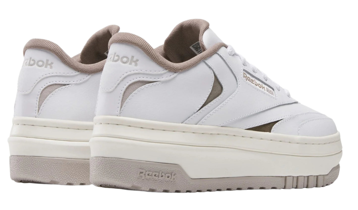 A pair of white platform sneakers with cutouts and the text "Reebok" on the sides and heels.