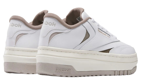 A pair of white platform sneakers with cutouts and the text "Reebok" on the sides and heels.
